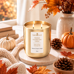Load image into Gallery viewer, A gold glass Tabor Olive candle sitting on a marble platform. Two lit wicks with calm flames surrounded by fall and autumn decor. Label reads "Tabor Olive Premium Coconut Wax Candle Made with pure essential oils natural organic vegan 12oz"