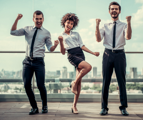 Two men and a woman in business attire standing outside showing excitement and joy. 