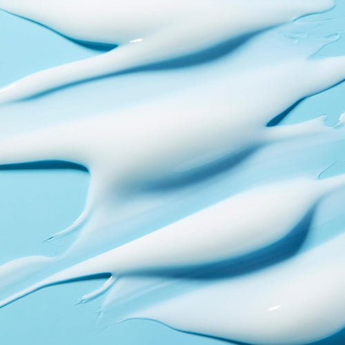 Picture of swirled white moisturizer on a teal surface