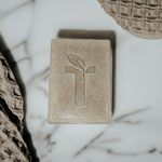 Load image into Gallery viewer, Bar Soap laying on marble platform next to a towel
