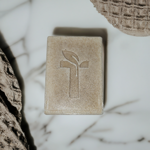 Bar Soap laying on marble platform next to a towel