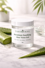 Load image into Gallery viewer, Jar of Tabor Olive Premium Soothing Aloe Vera Gel on a marble surface with aloe vera leaves.
