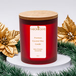 Load image into Gallery viewer, Red candle with a wooden lid on a white base, surrounded by festive gold leaves and green garland.

